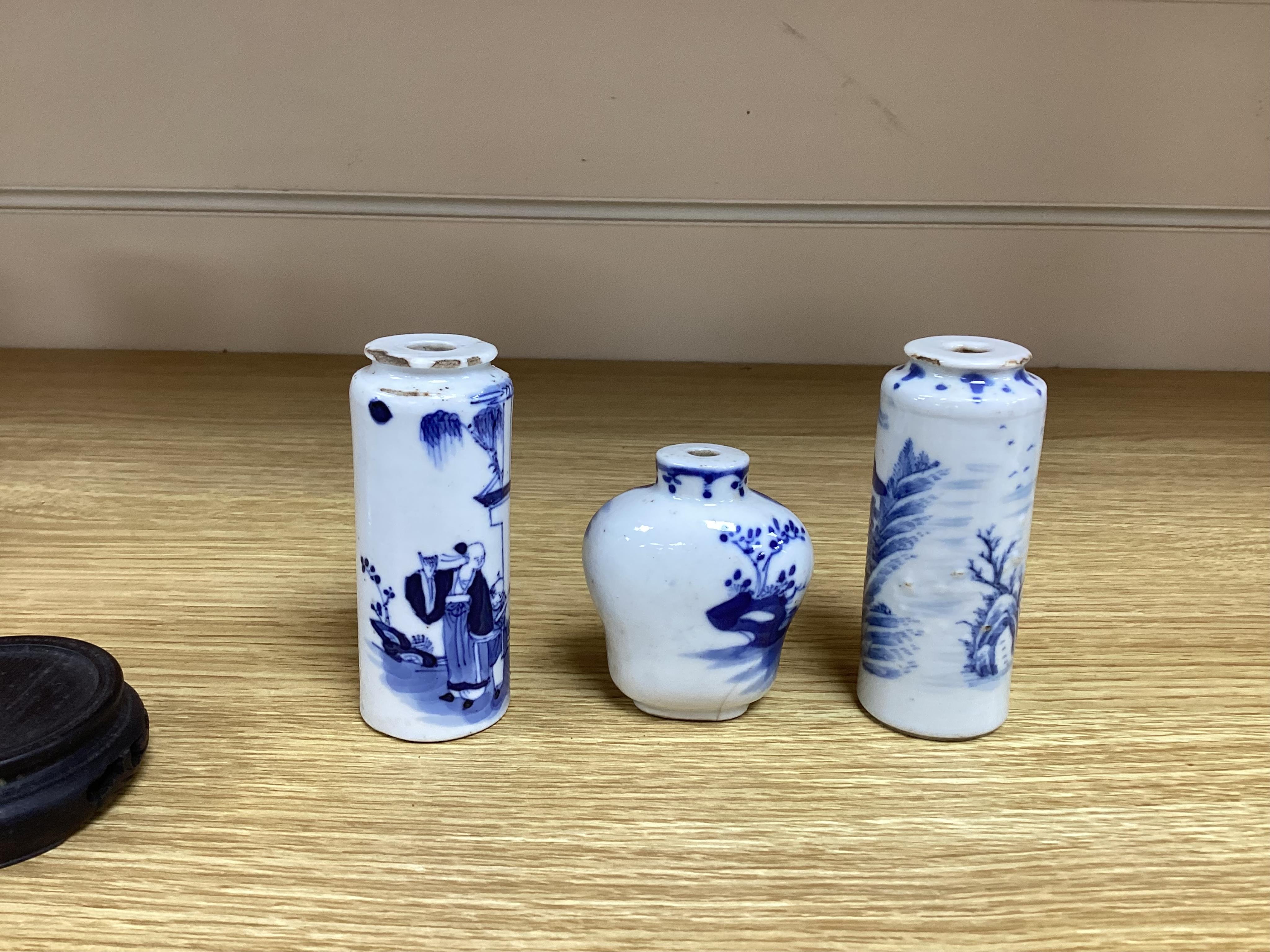 Three Chinese blue and white snuff bottles and three hardwood stands, largest 8cm high. Condition - poor to fair